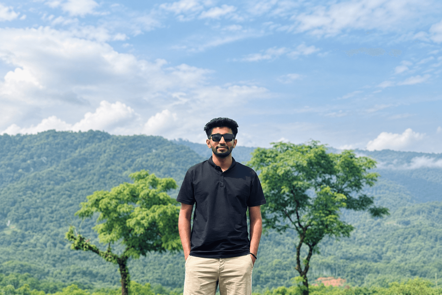 Iktiup Mahmud Seyam standing in front of green hills